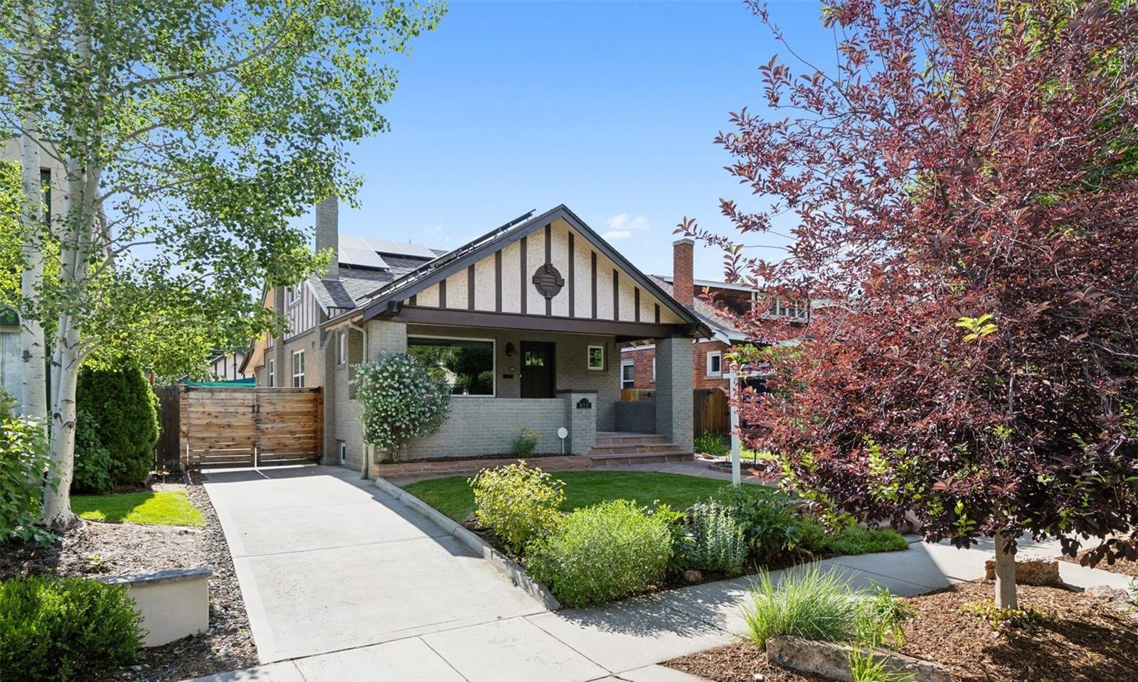 A classic Denver bungalow with a covered front porch and landscaped yard